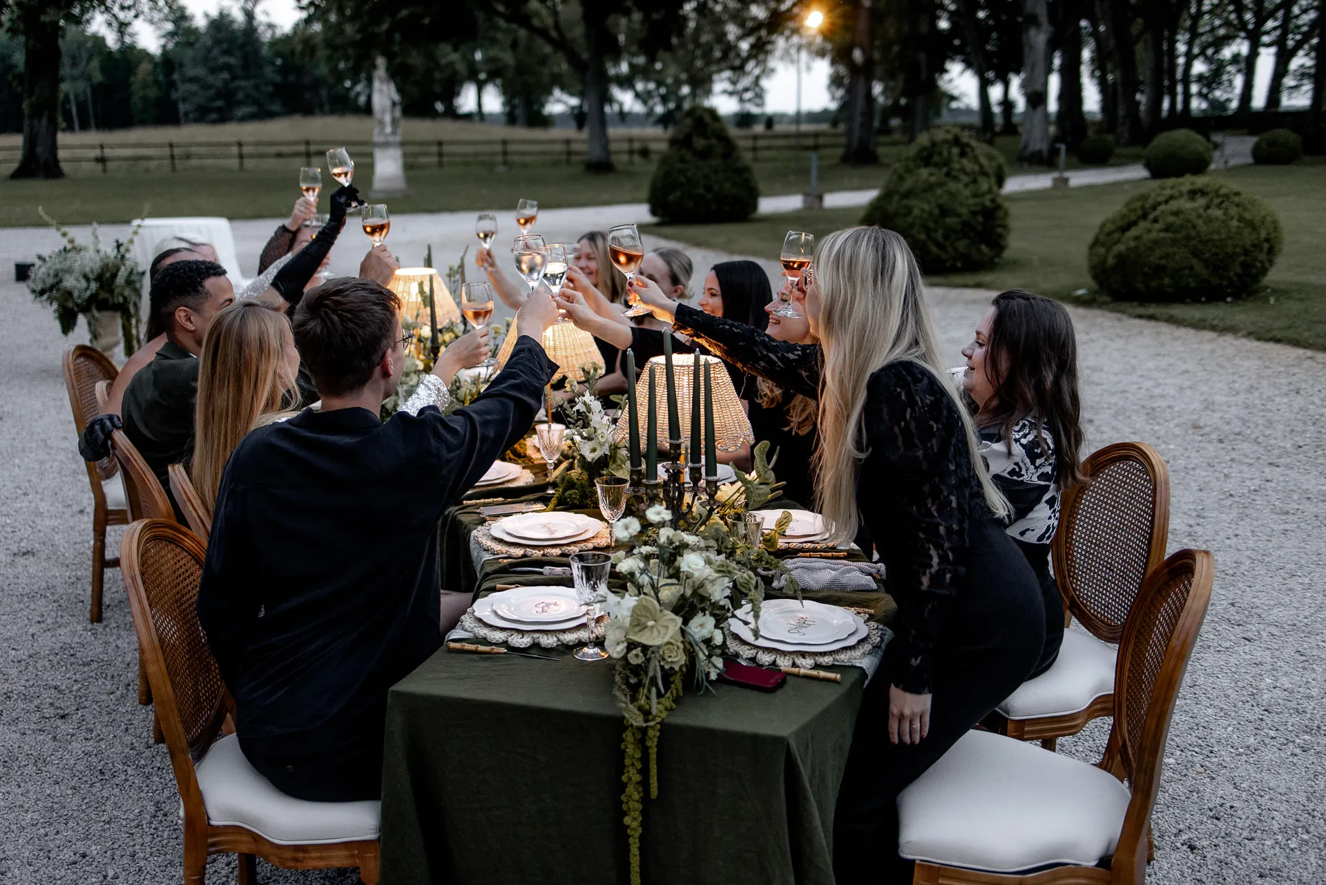 Wedding guests toasting with champagne at luxurious evening celebration at Chateau de Varennes